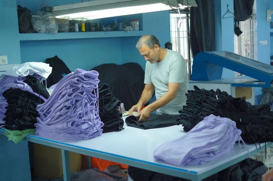 Quality control — worker inspecting finished garments